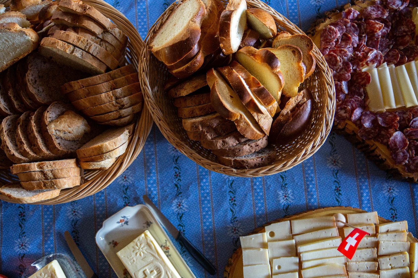 Ein Brunch-Buffet-Tisch mit Brot, Zopf, Fleisch, Käse und Butter.